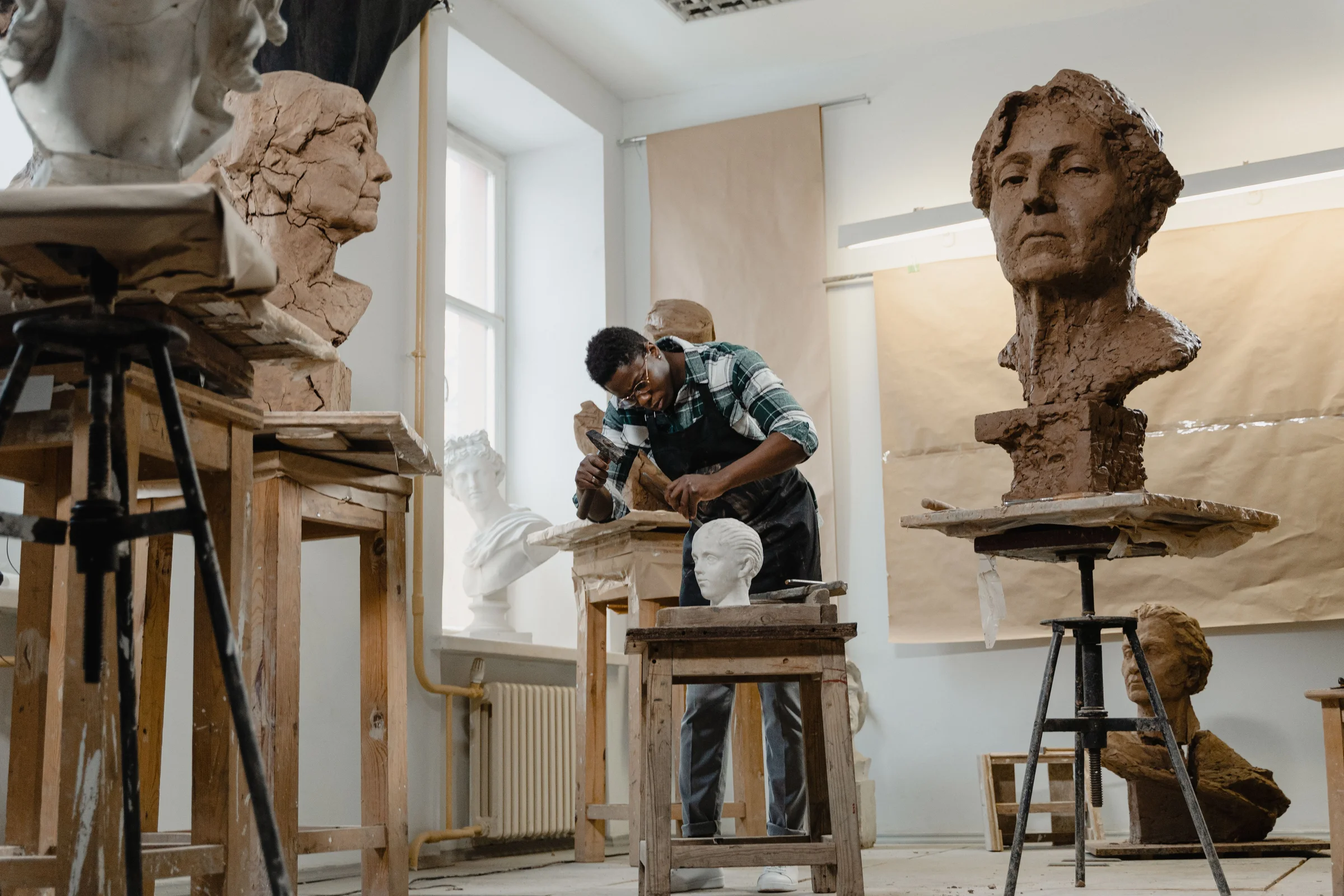 An artist working on a clay sculpture in a studio